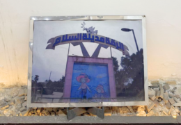 Straßenplakat zerstört auf dem Boden: darauf eine Grafik eines Mädchens und den Titel "Raqqa, die Stadt des Friedens" auf arabisch